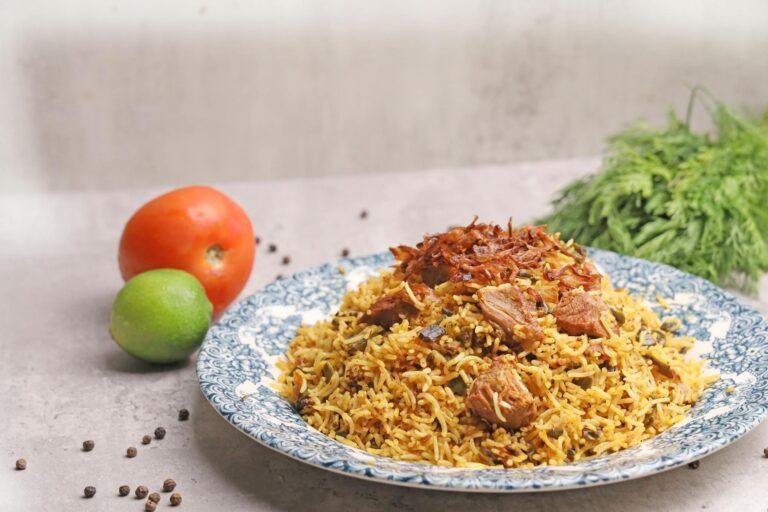 A plate of rice with meat and vegetables on it